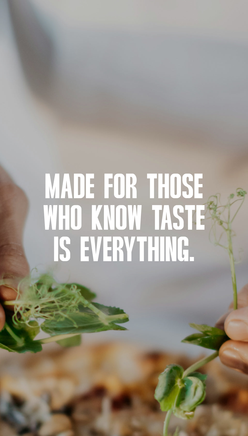 Tattooed hands finishing a wood-fired pizza with fresh micro-greens